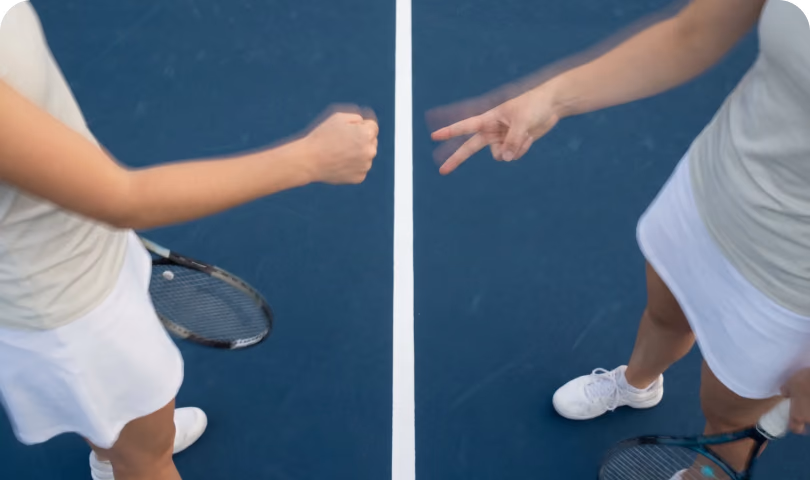 Two players playing Rock Paper Scissors at the net